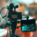 Close-up of a modern professional camera with monitor mounted on a tripod, ideal for filmmaking.