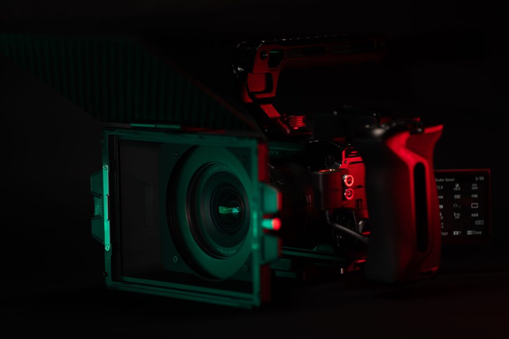 Close-up of a cinema camera rig with striking neon lighting, perfect for videography setups.